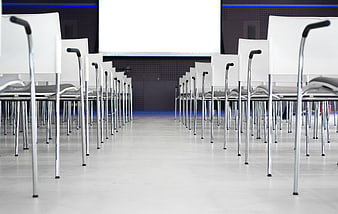 Empty modern conference room with rows of white chairs