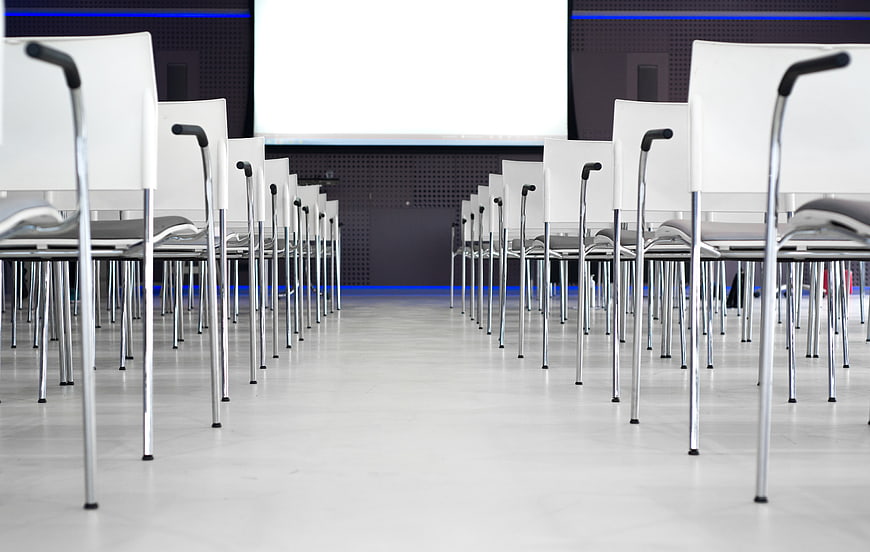 Empty modern conference room with rows of white chairs