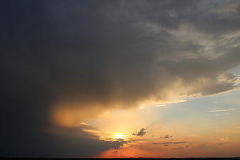 Dramatic sunset with golden light breaking through dark storm clouds