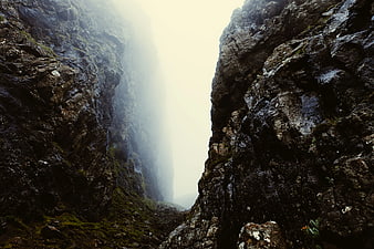 Misty Mountain Gorge with Dark Rocky Cliffs