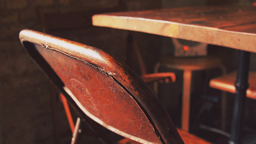 Close-up of vintage wooden chair back in rustic cafe