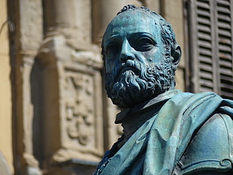 Close-up of weathered bronze bust statue with blue patina