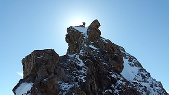 Alpine Climber Reaching Summit of Snowy Rock Peak in Swiss Alps