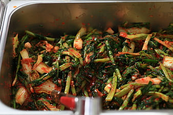 Freshly prepared Korean radish kimchi in a stainless steel food pan