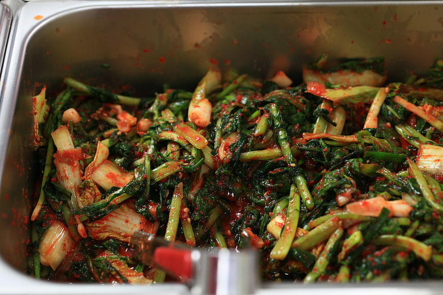 Freshly prepared Korean radish kimchi in a stainless steel food pan