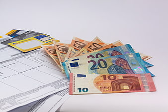 Euro banknotes, credit cards, and financial documents on white background