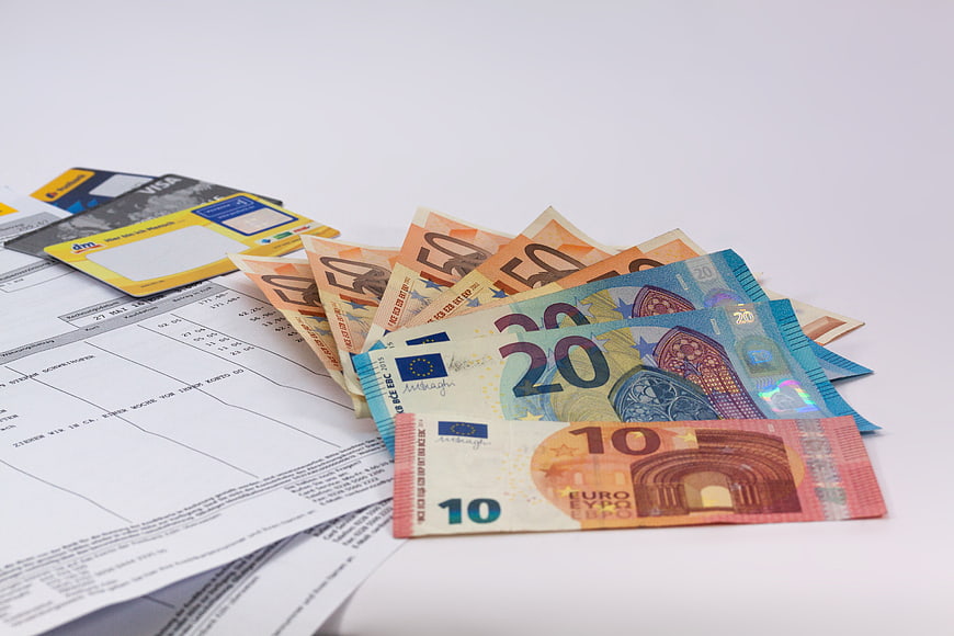 Euro banknotes, credit cards, and financial documents on white background