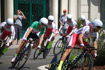 Cyclists racing in a team time trial on a sunny street