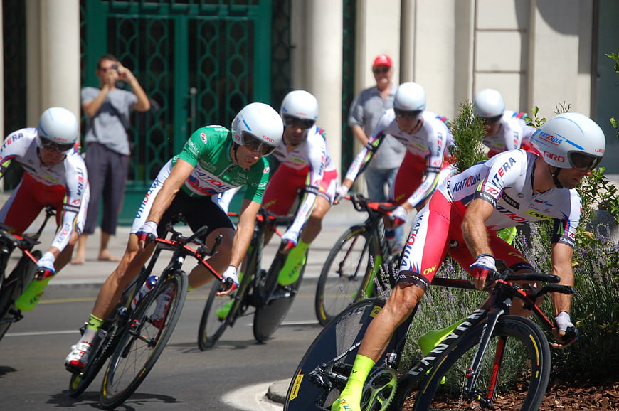 Cyclists racing in a team time trial on a sunny street