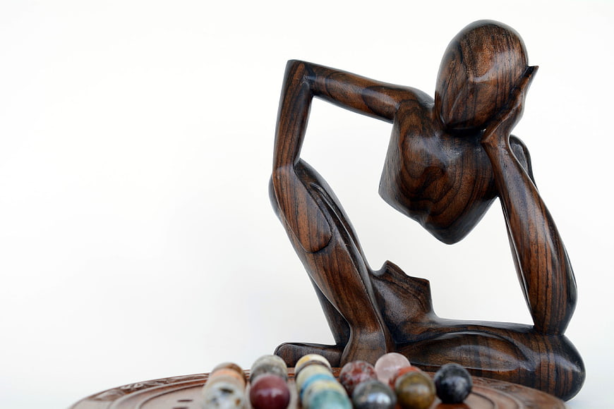 Wooden Thinker Sculpture With Marbles On White Background