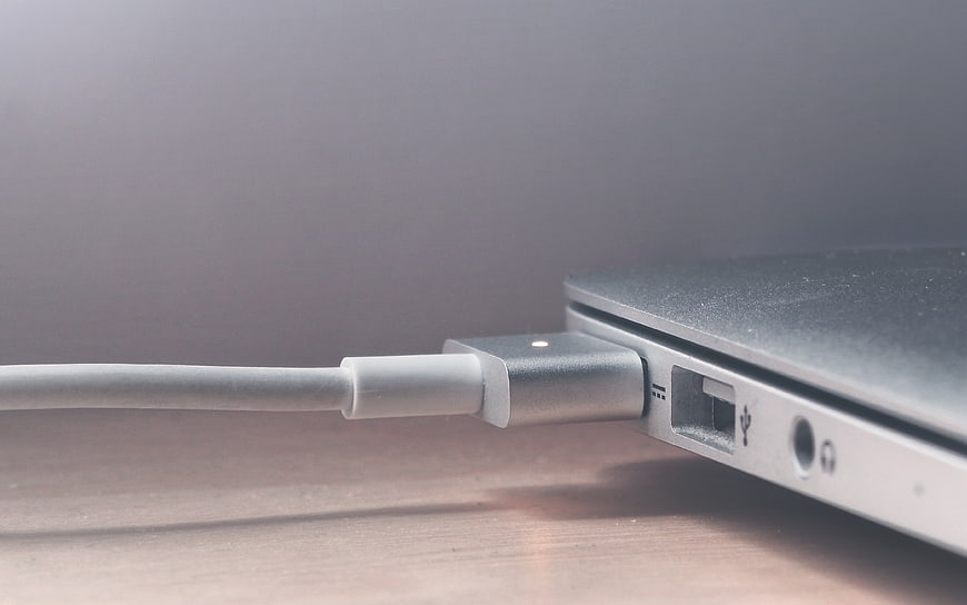 Close-up of USB-C cable plugged into silver laptop