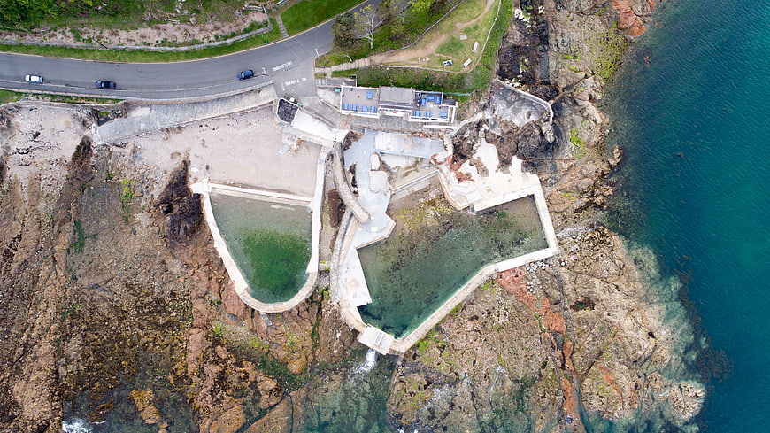 Aerial view of coastal rock pools and cliffside road