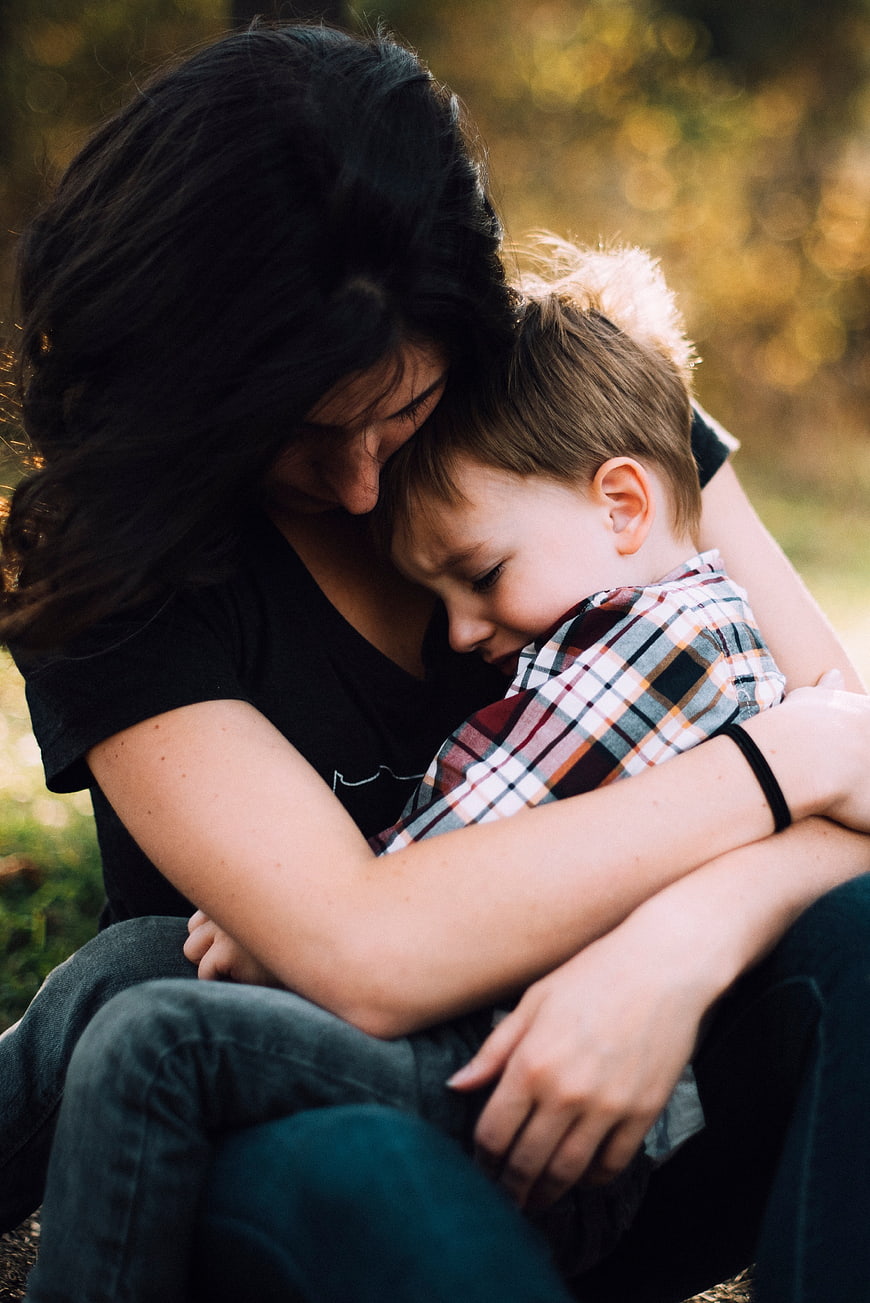 Mother Hugging Son in Park at Sunset