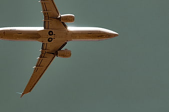 Commercial Airplane Flying Overhead Against Blue Sky