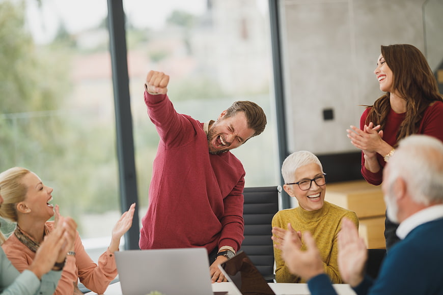 Diverse business team celebrating success in modern office meeting