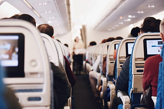 Passengers seated in airplane cabin aisle view