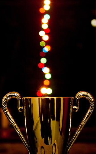 Golden trophy cup with colorful bokeh lights background