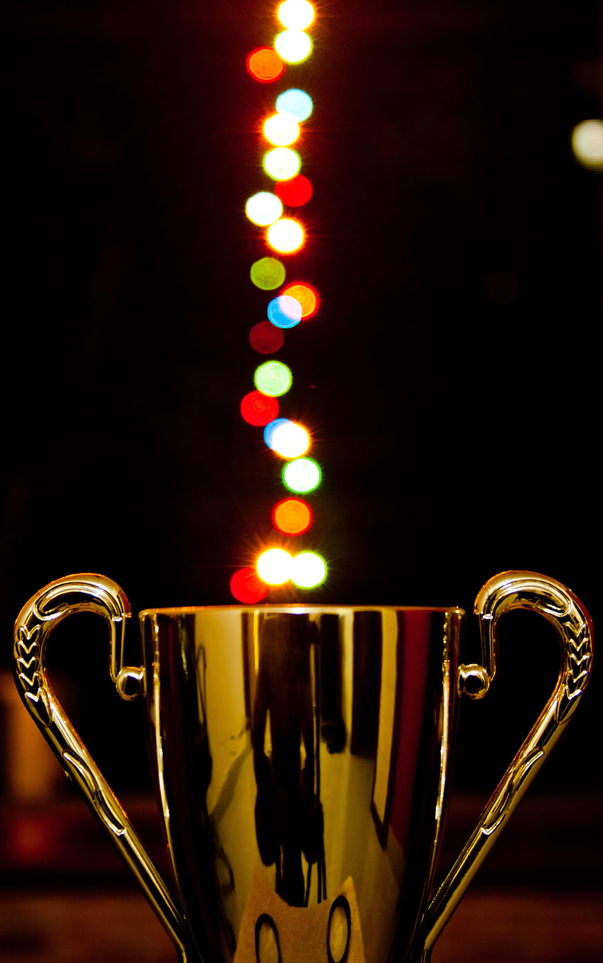 Golden trophy cup with colorful bokeh lights background