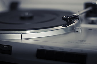 Close-up of silver turntable tonearm and vinyl record