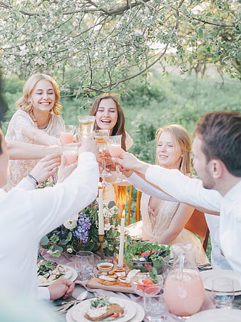 Friends toasting with drinks at a summer garden party