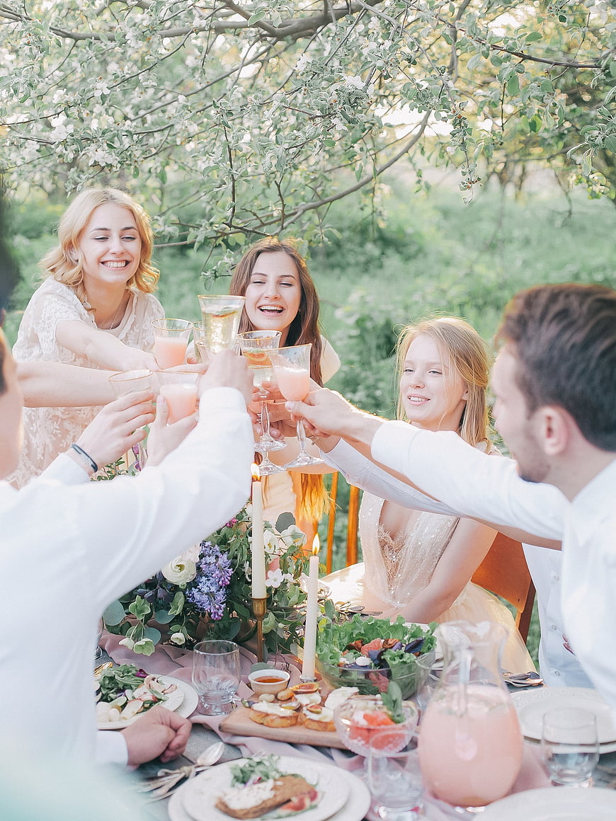 Friends toasting with drinks at a summer garden party