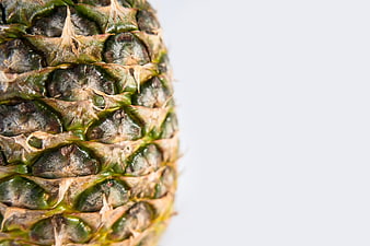 Close-up of textured pineapple skin on white background