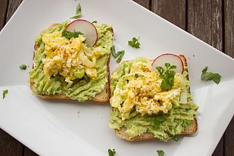 Avocado Toast with Scrambled Eggs and Radish on White Plate