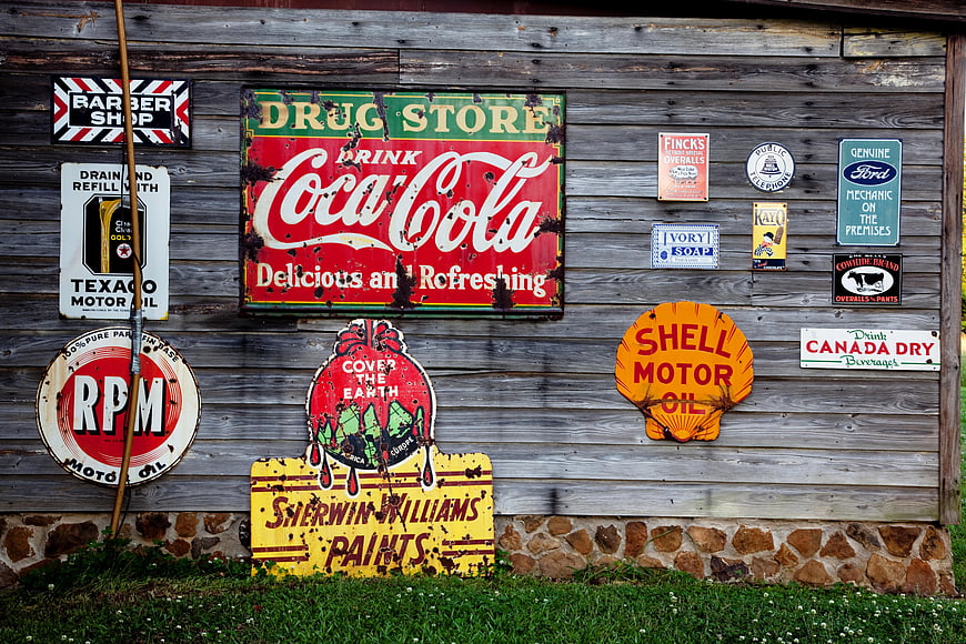 Vintage Rustic Tin Signs on Weathered Wooden Barn Wall