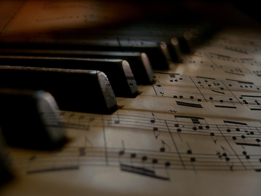 Close-up of piano keys on vintage sheet music