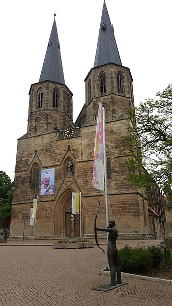 Historic twin-towered church with archer statue in Duderstadt