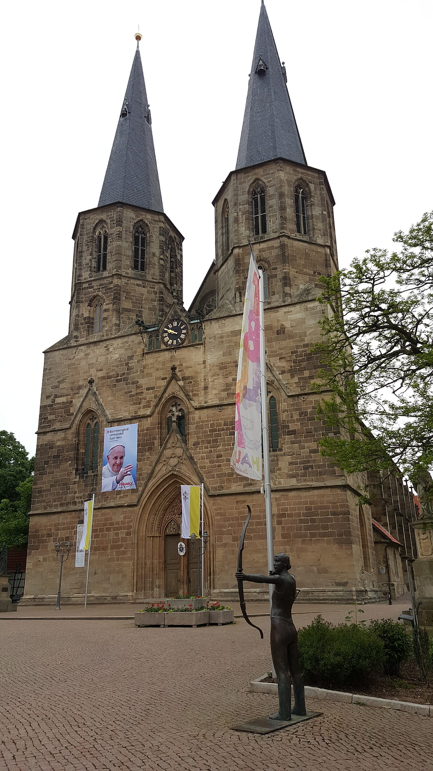Historic twin-towered church with archer statue in Duderstadt