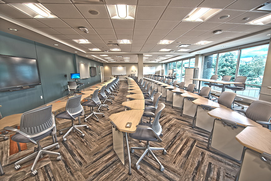 Modern empty university lecture hall with rows of desks and chairs