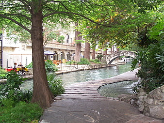 San Antonio Riverwalk Pathway With Stone Bridge And Lush Greenery