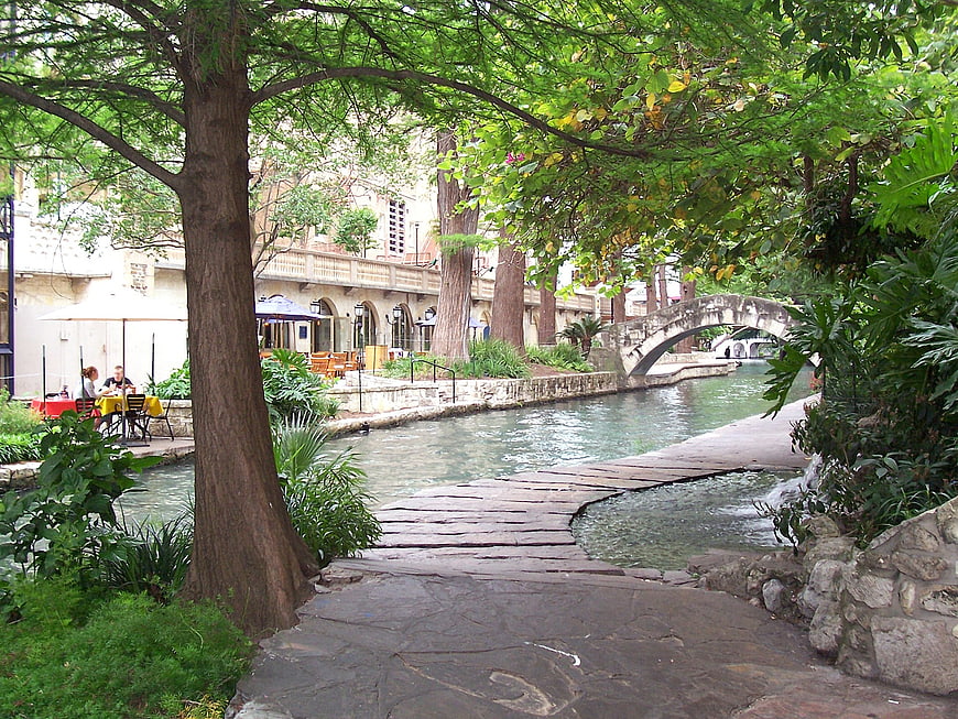 San Antonio Riverwalk Pathway With Stone Bridge And Lush Greenery