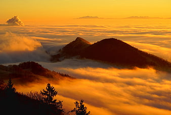 Golden Sunrise Over Mountain Peaks and Sea of Clouds