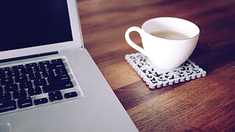 White Coffee Cup on Coaster Next to Laptop on Wooden Desk