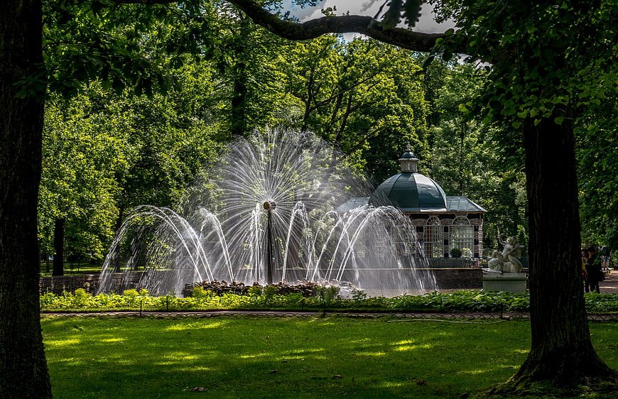 Springsbrunnen fountain in lush green park with pavilion