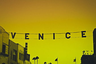 Venice Beach Hanging Sign Silhouette Against Yellow Sky