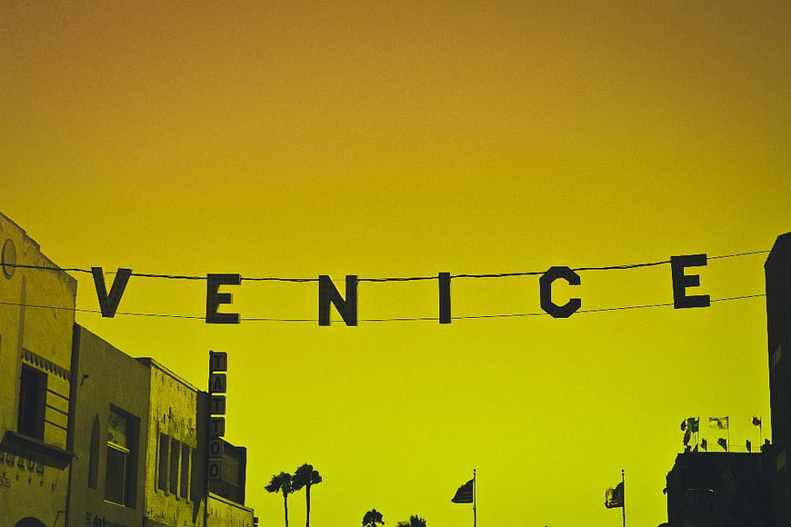 Venice Beach Hanging Sign Silhouette Against Yellow Sky