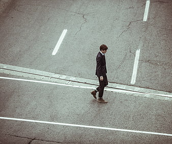 High angle view of businessman walking across city street