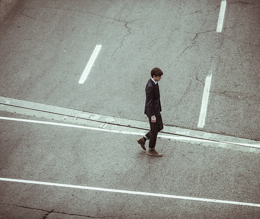 High angle view of businessman walking across city street