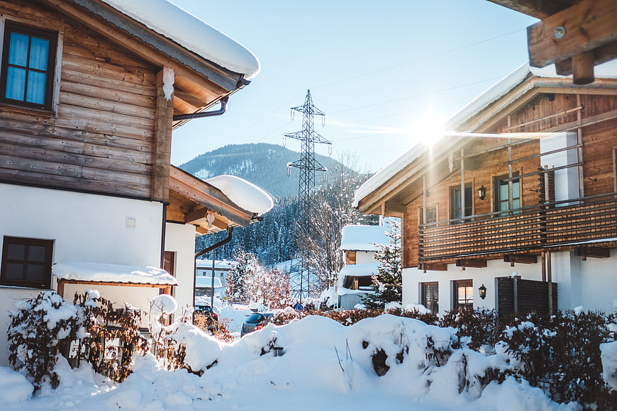 Snowy Alpine Chalets with Sun Flare and Power Lines