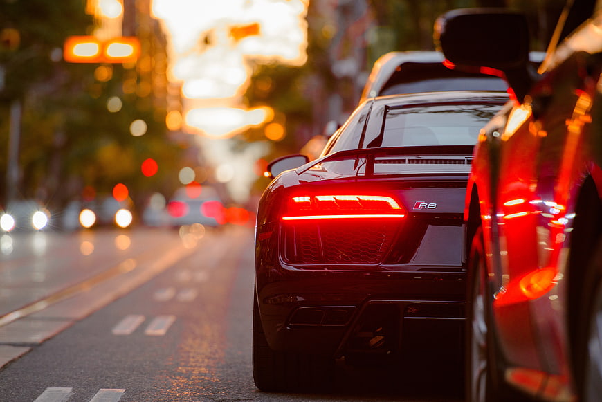 Rear View of Black Audi R8 on City Street at Sunset