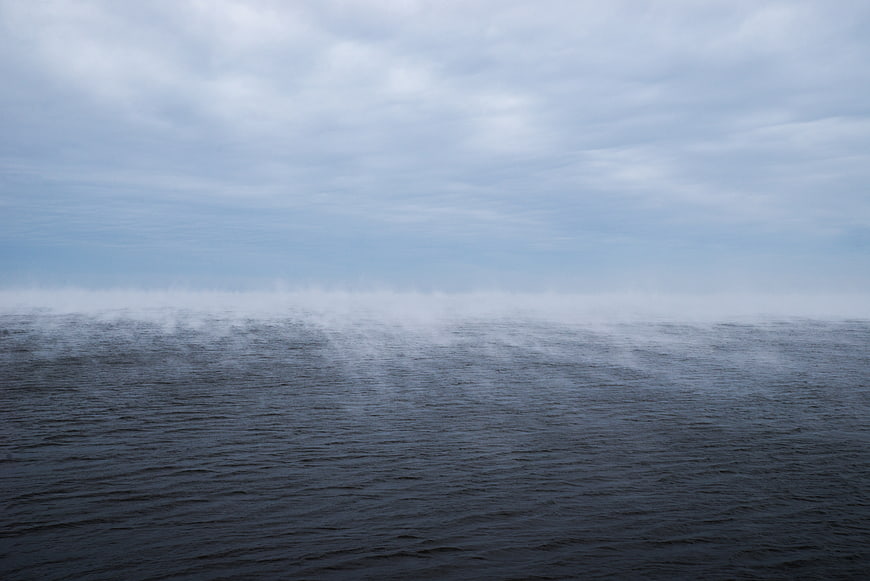 Misty ocean horizon with dark water and overcast sky