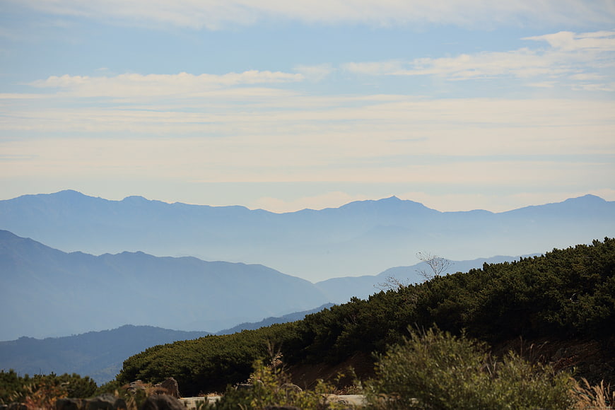 Serene Mountain Landscape with Atmospheric Haze and Blue Sky