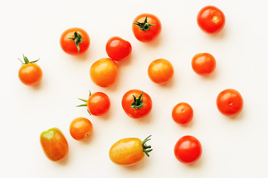 Fresh Cherry Tomatoes Scattered On White Background