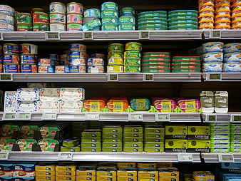 Supermarket shelves stocked with colorful canned fish products