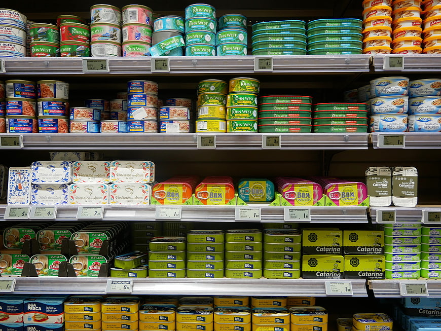Supermarket shelves stocked with colorful canned fish products
