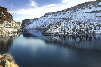 Snowy Mountain Ravine with Calm River Reflection
