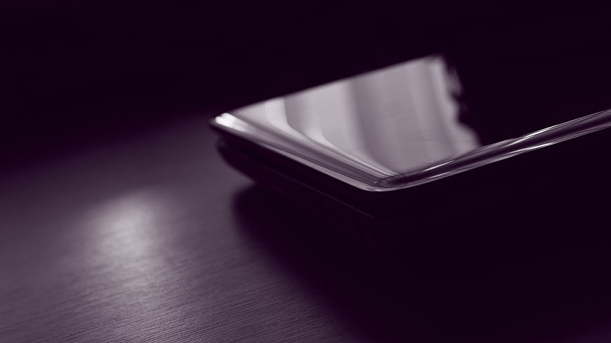 Close-up of a smartphone screen on a dark wooden table